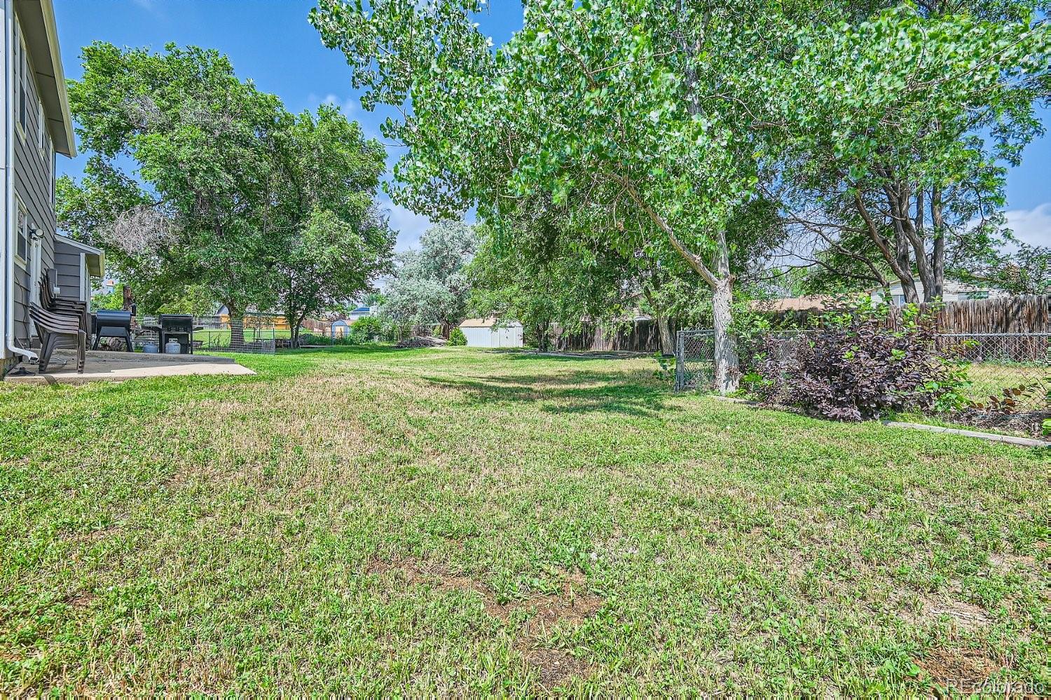 11099 Fairfax Circle Thornton, CO 80233 - Photo 32 of 33 a view of a grassy field with trees in the background