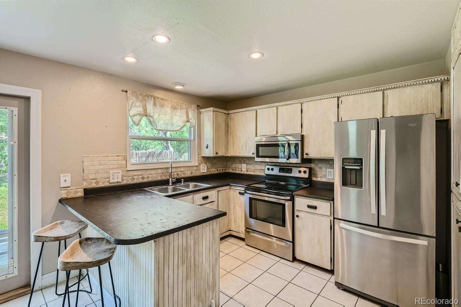 11099 Fairfax Circle Thornton, CO 80233 - Photo 10 of 33 a kitchen with stainless steel appliances granite countertop a refrigerator a stove a sink and a refrigerator