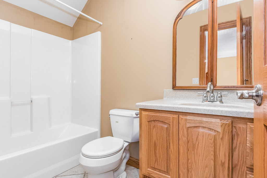 331 Rickert Street Hinckley, IL 60520 - Photo 11 of 19 a bathroom with a granite countertop sink a toilet and a bathtub