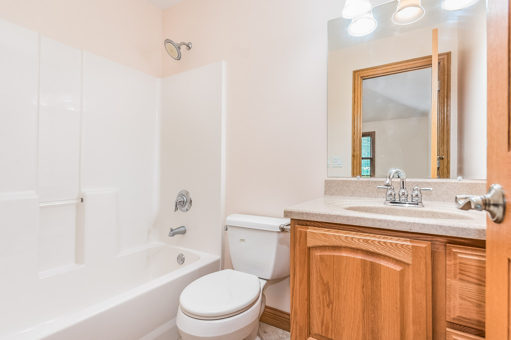 331 Rickert Street Hinckley, IL 60520 - Photo 13 of 19 a bathroom with a granite countertop toilet a sink and a bathtub