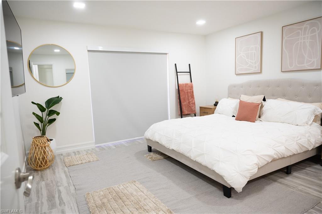 136 Harrison Road, Unit L3 Naples, FL 34112 - Photo 34 of 50 a bedroom with a bed flowerpot and a mirror