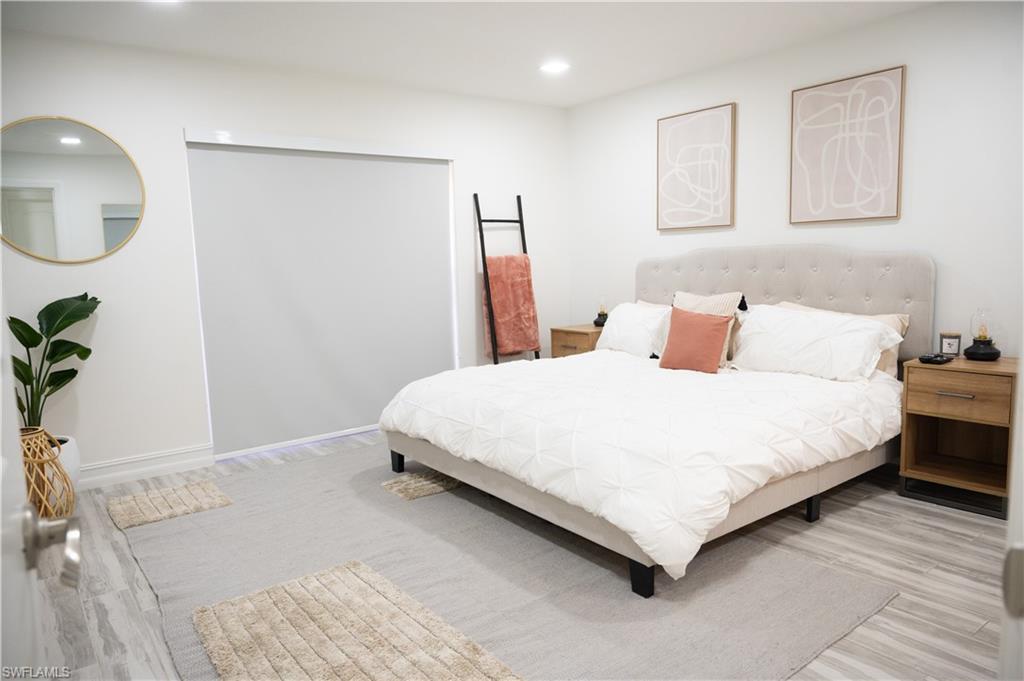 136 Harrison Road, Unit L3 Naples, FL 34112 - Photo 42 of 50 a bedroom with a bed mirror and a potted plant