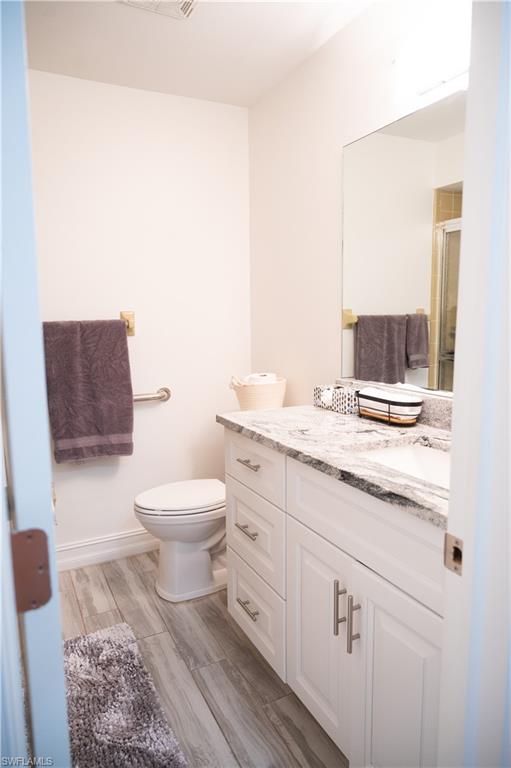 136 Harrison Road, Unit L3 Naples, FL 34112 - Photo 44 of 50 a bathroom with a granite countertop toilet sink and mirror