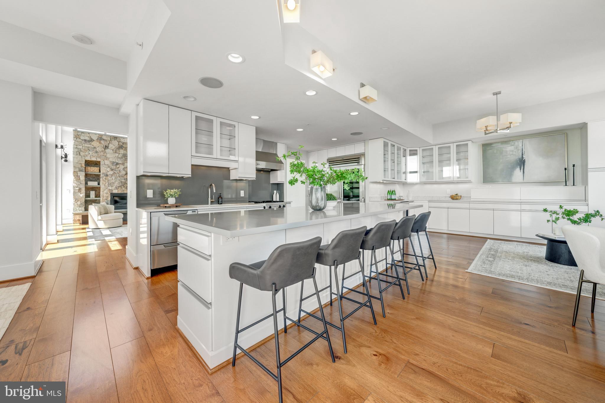 11990 Market Street, Unit 2112 Reston, VA 20190 - Photo 12 of 92 a kitchen with stainless steel appliances kitchen island granite countertop a table chairs stove and white cabinets