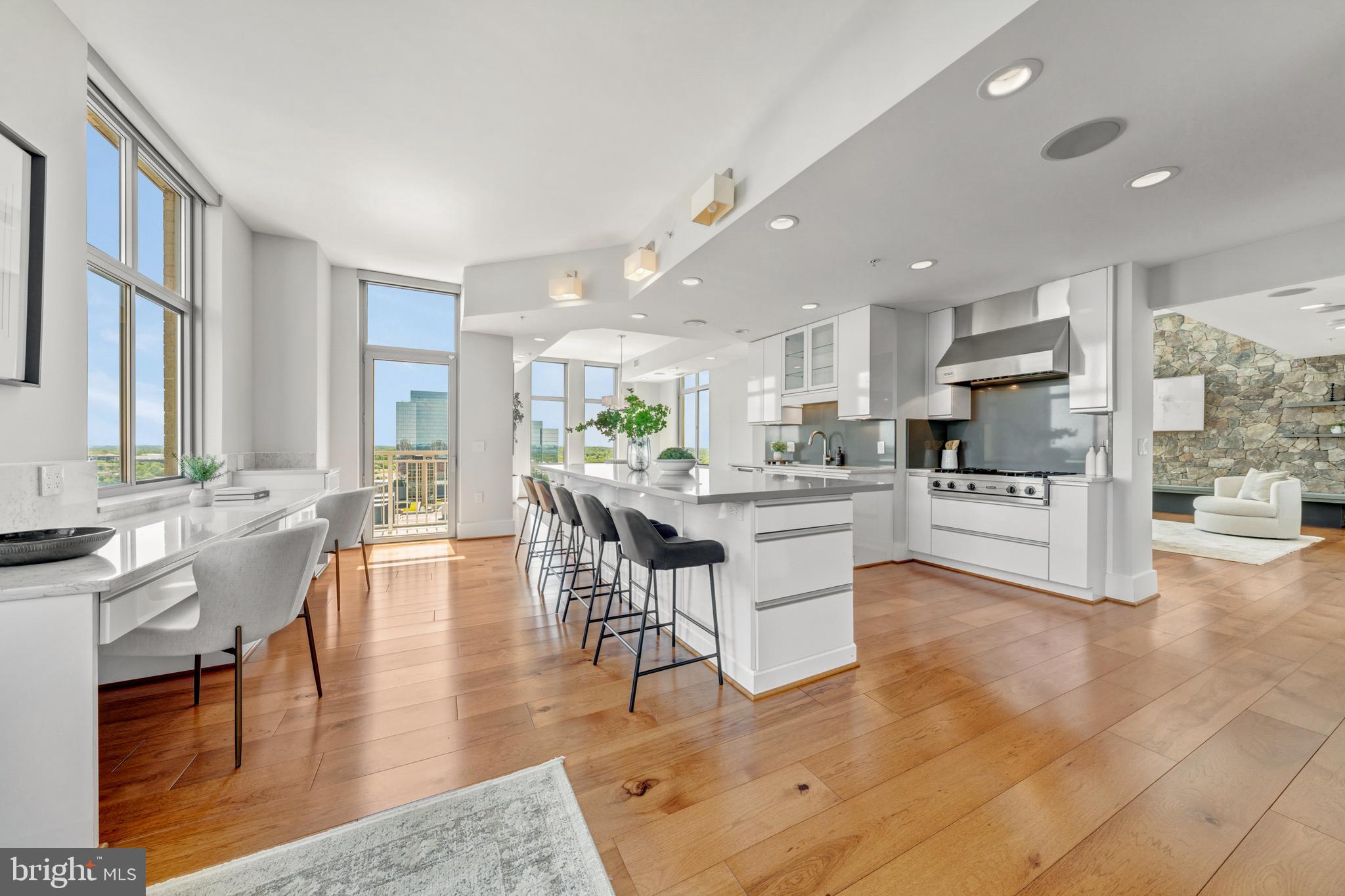 11990 Market Street, Unit 2112 Reston, VA 20190 - Photo 15 of 92 a kitchen with stainless steel appliances kitchen island granite countertop a stove a sink a dining table and chairs