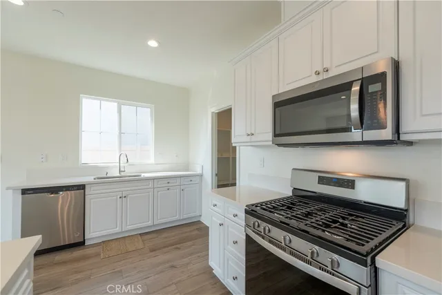 a kitchen with stainless steel appliances a stove a microwave and cabinets