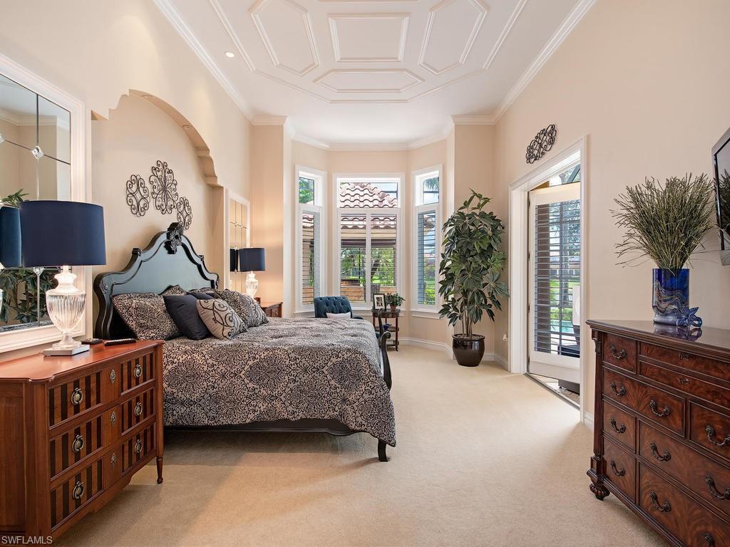 14903 Bellezza Lane Naples, FL 34110 - Photo 10 of 25 a bedroom with a bed and a chandelier