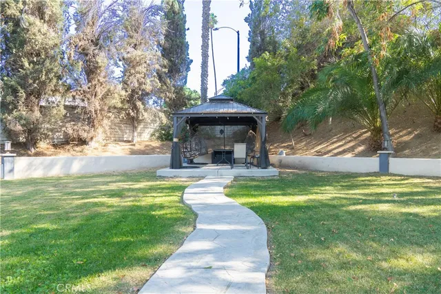 a view of a fountain in a yard with palm trees