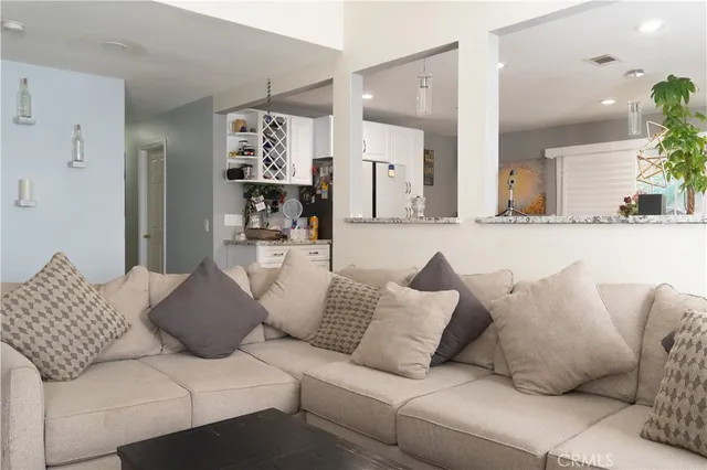 a living room with furniture white walls and painting on the wall