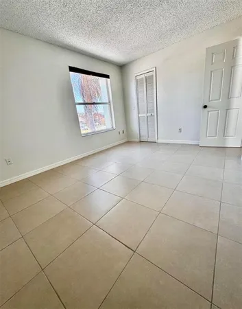 an empty room with windows and closet