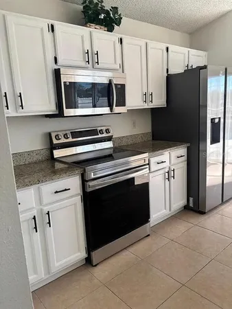 a kitchen with white cabinets and stainless steel appliances