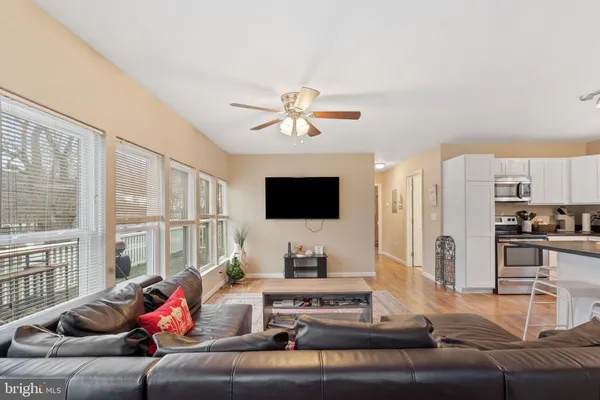 a kitchen with stainless steel appliances granite countertop a stove top oven a sink dishwasher a dining table and chairs with wooden floor