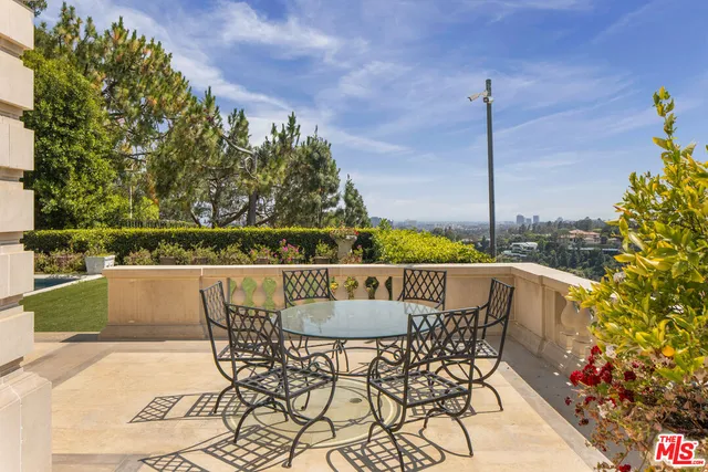 a kitchen with stainless steel appliances kitchen island granite countertop a dining table chairs sink and cabinets