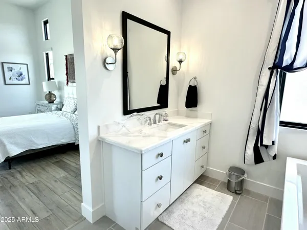 a spacious bathroom with a double vanity sink a mirror and a bathtub