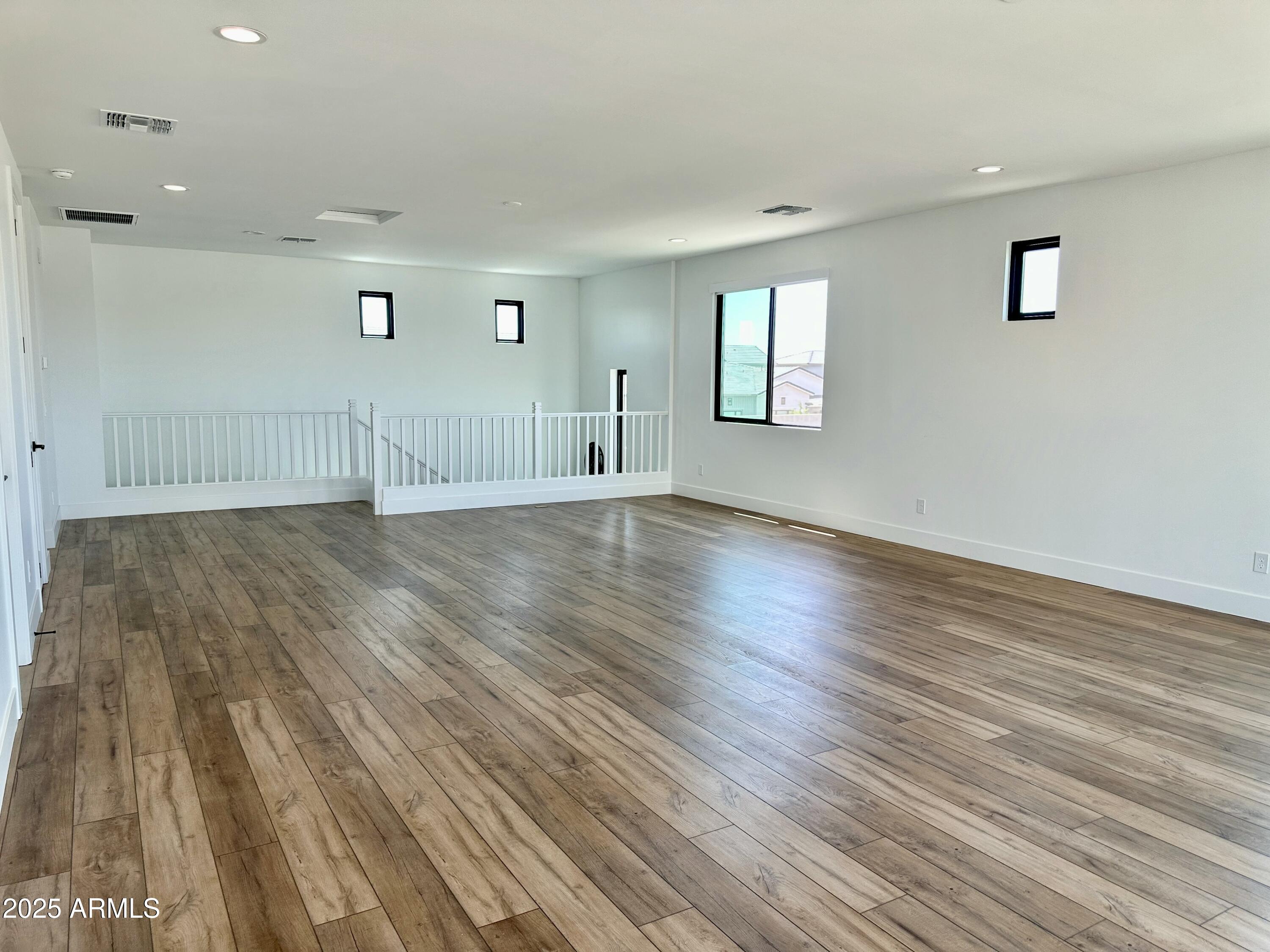 2725 East Derringer Court Gilbert, AZ 85297 - Photo 31 of 56 an empty room with wooden floor and windows