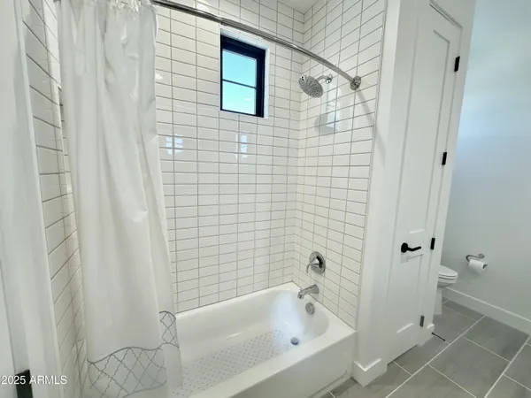 a view of an empty room with closet and wooden floor