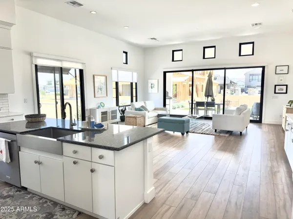 a kitchen with granite countertop a stove and white cabinets