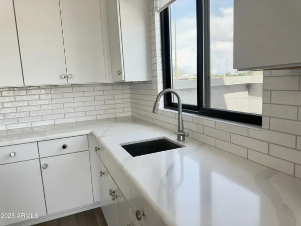 a kitchen with kitchen island granite countertop a sink a stove and cabinets