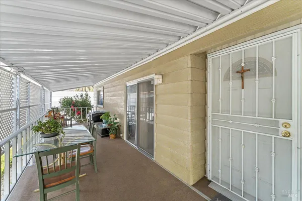 a view of a porch with chairs and potted plants