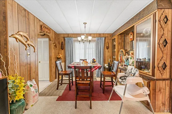 a dining room with furniture a chandelier and wooden floor
