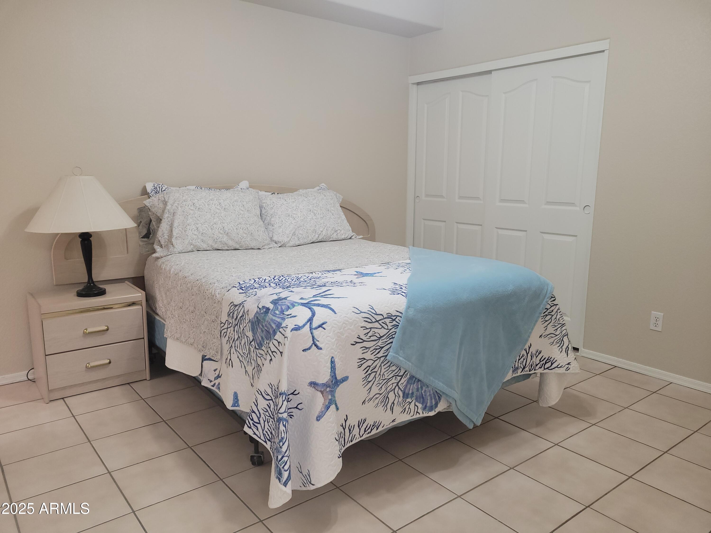 6001 East Southern Avenue, Unit 4 Mesa, AZ 85206 - Photo 11 of 23 a bedroom with a bed and a lamp on table