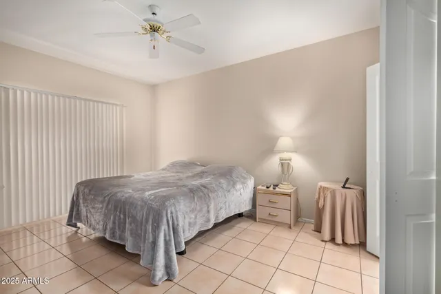 a bed sitting in a bedroom next to a window and a chandelier