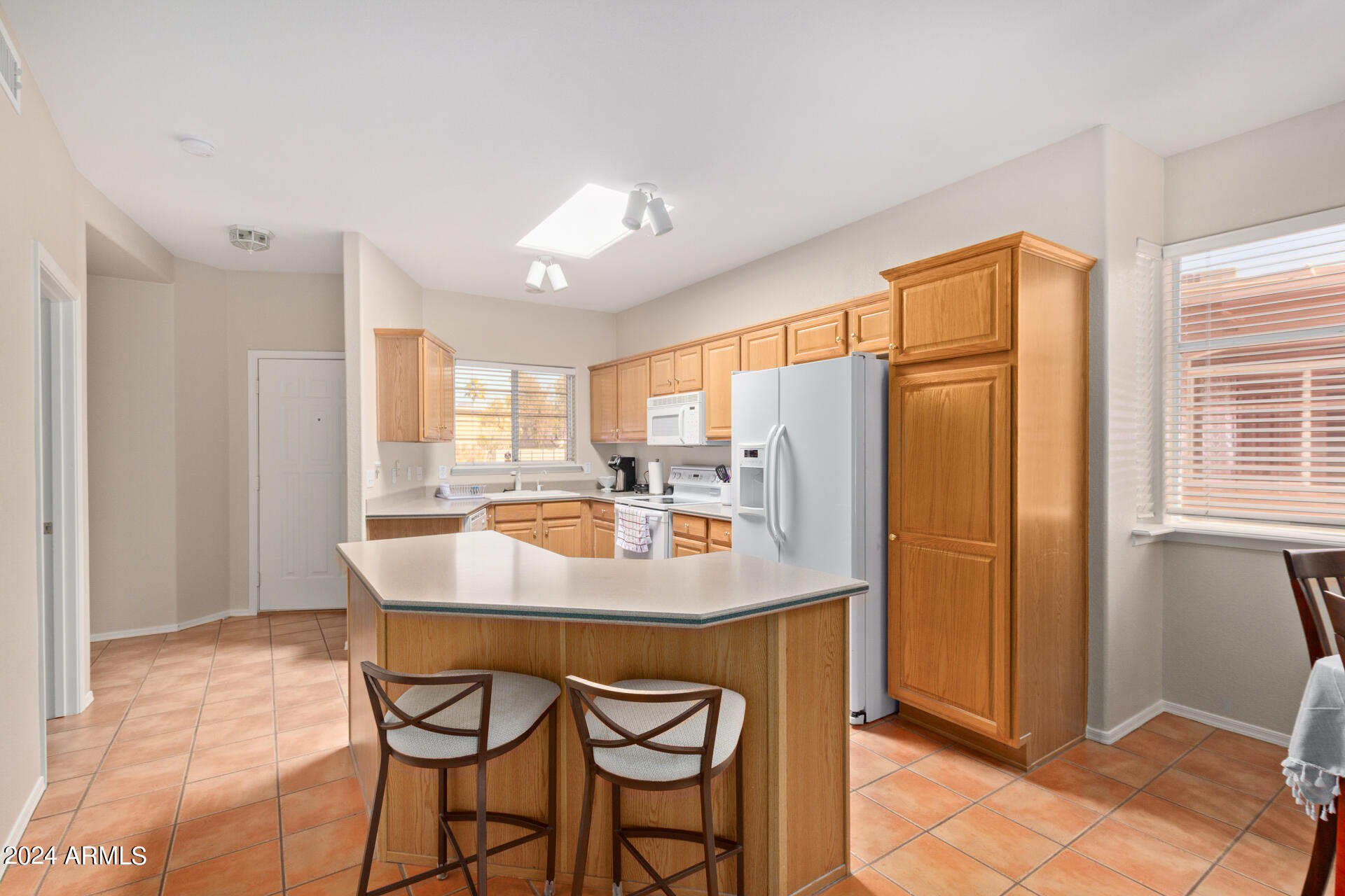 6001 East Southern Avenue, Unit 4 Mesa, AZ 85206 - Photo 4 of 23 a kitchen with stainless steel appliances granite countertop a table chairs and a refrigerator