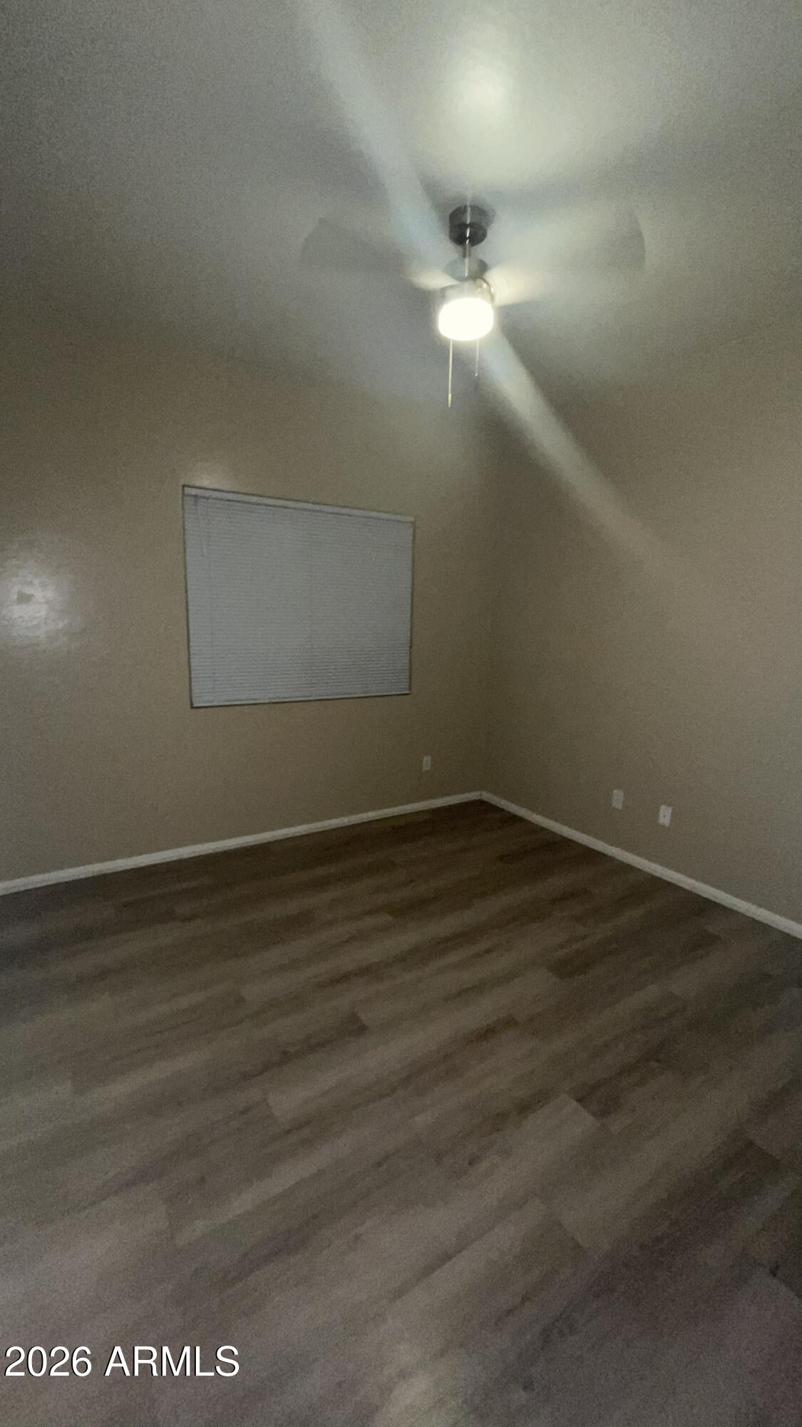 10640 West Coronado Road Avondale, AZ 85392 - Photo 17 of 26 an empty room with wooden floor and windows