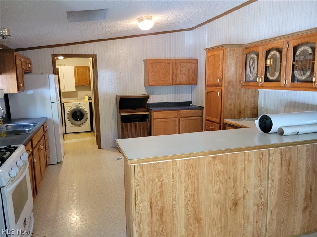2450 Ferguson Road McConnelsville, OH 43756 - Photo 5 of 13 Kitchen with kitchen peninsula, lofted ceiling, a textured ceiling, washer / clothes dryer, and light tile flooring