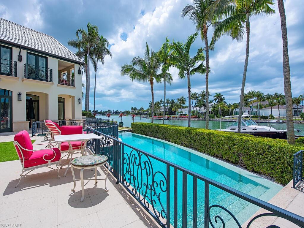 3580 Gin Lane Naples, FL 34102 - Photo 12 of 38 a swimming pool with outdoor seating and yard