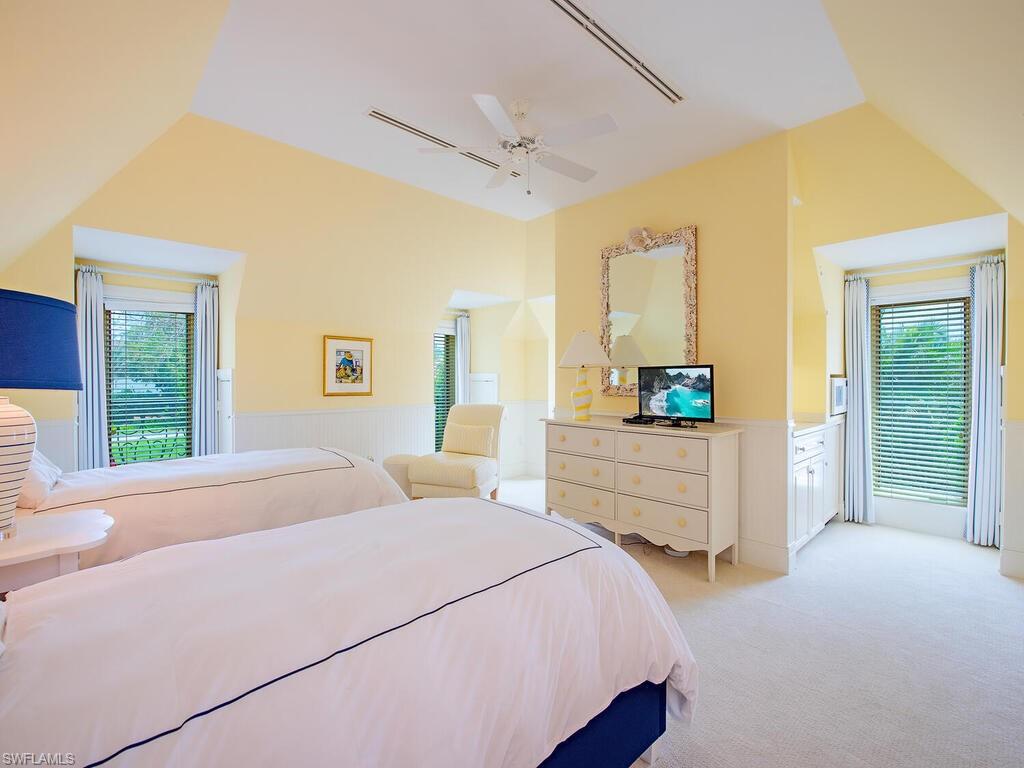 3580 Gin Lane Naples, FL 34102 - Photo 28 of 38 a bedroom with a bed a large window with table and chair