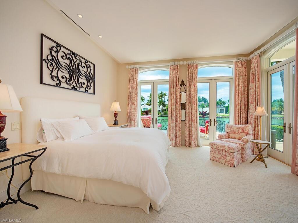 3580 Gin Lane Naples, FL 34102 - Photo 30 of 38 a bedroom with a bed and glass walk in closet