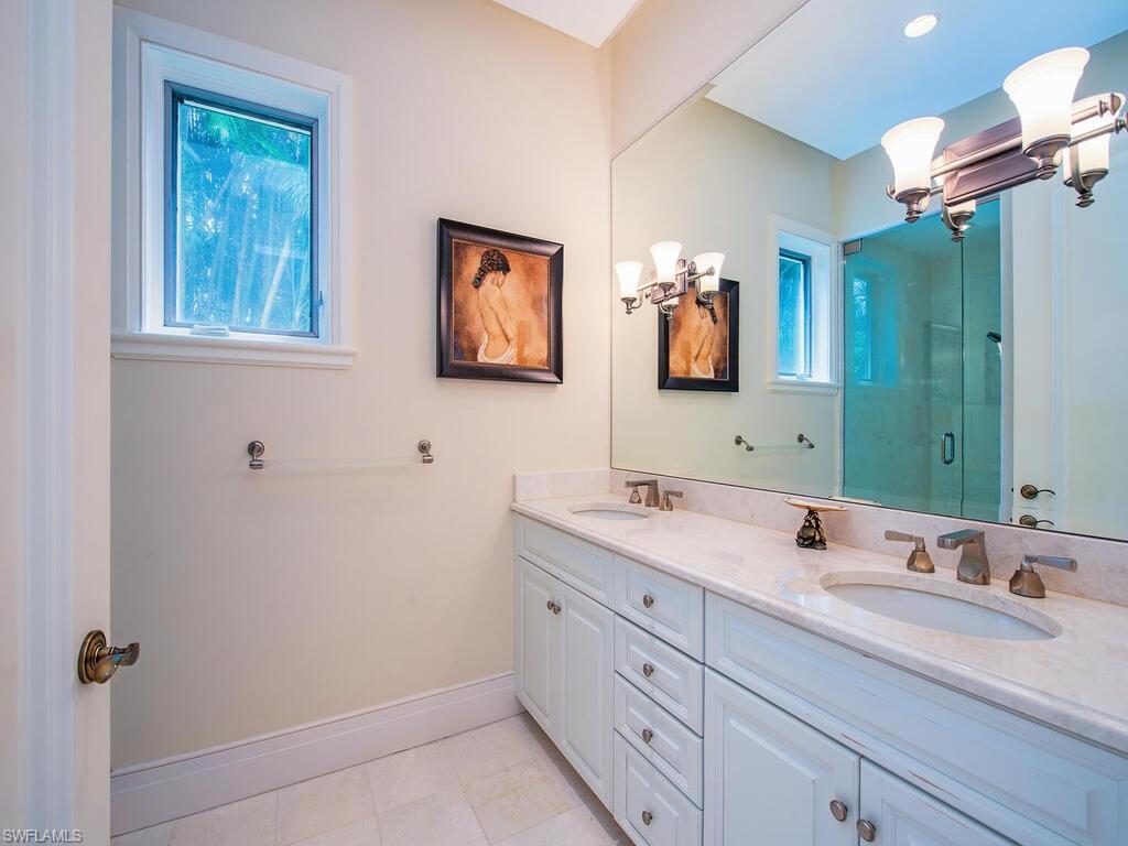 3580 Gin Lane Naples, FL 34102 - Photo 31 of 38 a bathroom with a double vanity sink and a mirror