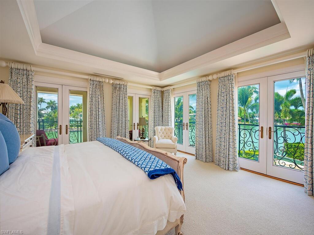 3580 Gin Lane Naples, FL 34102 - Photo 32 of 38 a bed sitting in front of a bedroom next to a large window