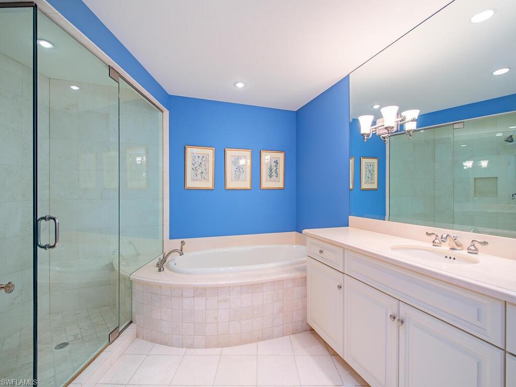 3580 Gin Lane Naples, FL 34102 - Photo 34 of 38 a bathroom with a tub a sink and mirror