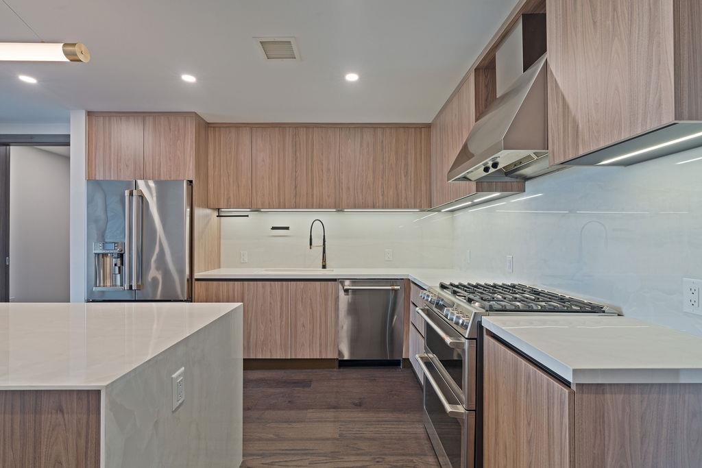 8701 Churchill Road, Unit 502 North Bergen, NJ 07047 - Photo 18 of 37 a kitchen with a sink a refrigerator and cabinets
