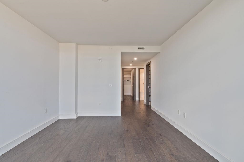 8701 Churchill Road, Unit 502 North Bergen, NJ 07047 - Photo 7 of 37 a view of an empty room with wooden floor
