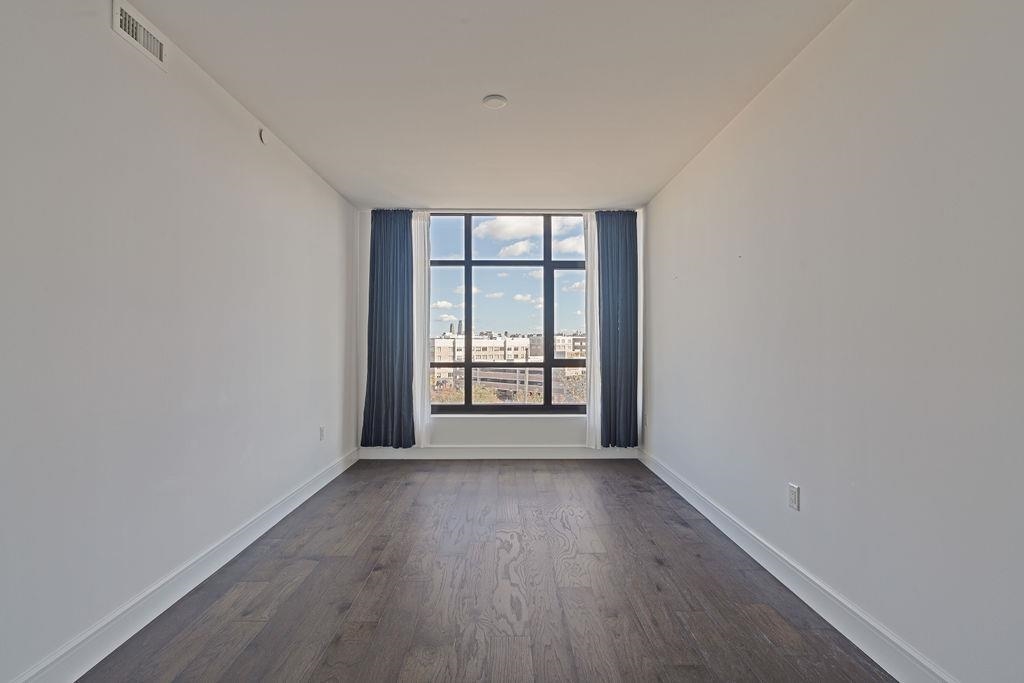 8701 Churchill Road, Unit 502 North Bergen, NJ 07047 - Photo 8 of 37 wooden floor in an empty room with a window