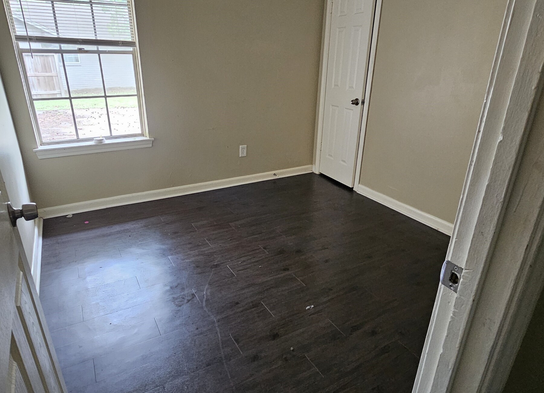 3303 Roaming Woods Lane Spring, TX 77380 - Photo 10 of 21 an empty room with wooden floor and windows with curtains