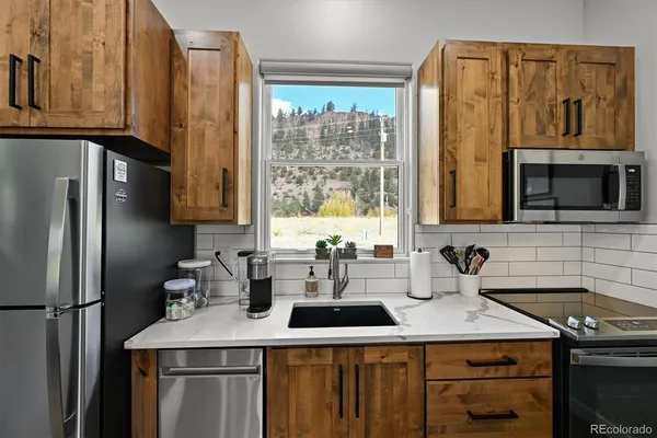 a kitchen with stainless steel appliances a sink stove and refrigerator