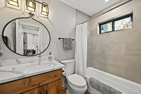 a bathroom with a sink a toilet and a mirror