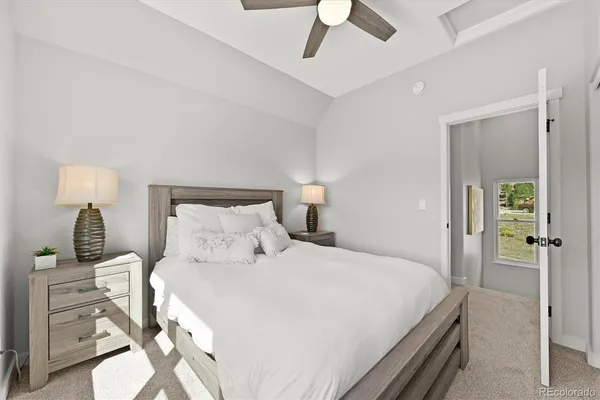 a bedroom with a bed a chandelier and a flat tv screen on a dresser