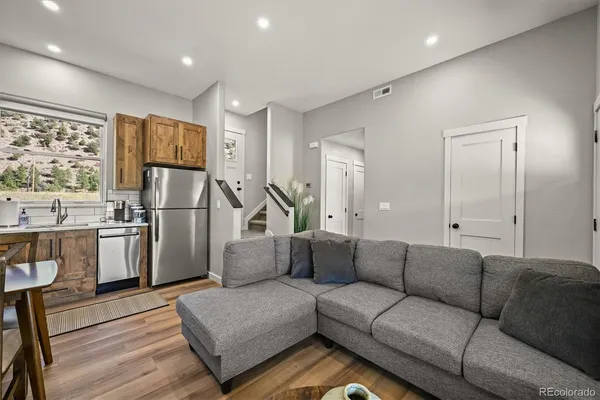 a living room with furniture and a refrigerator