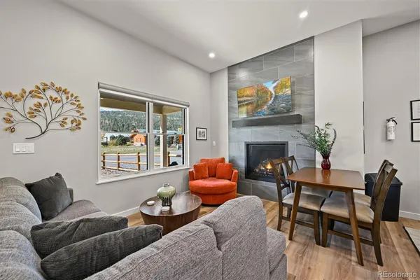 a living room with furniture a fireplace and a flat screen tv