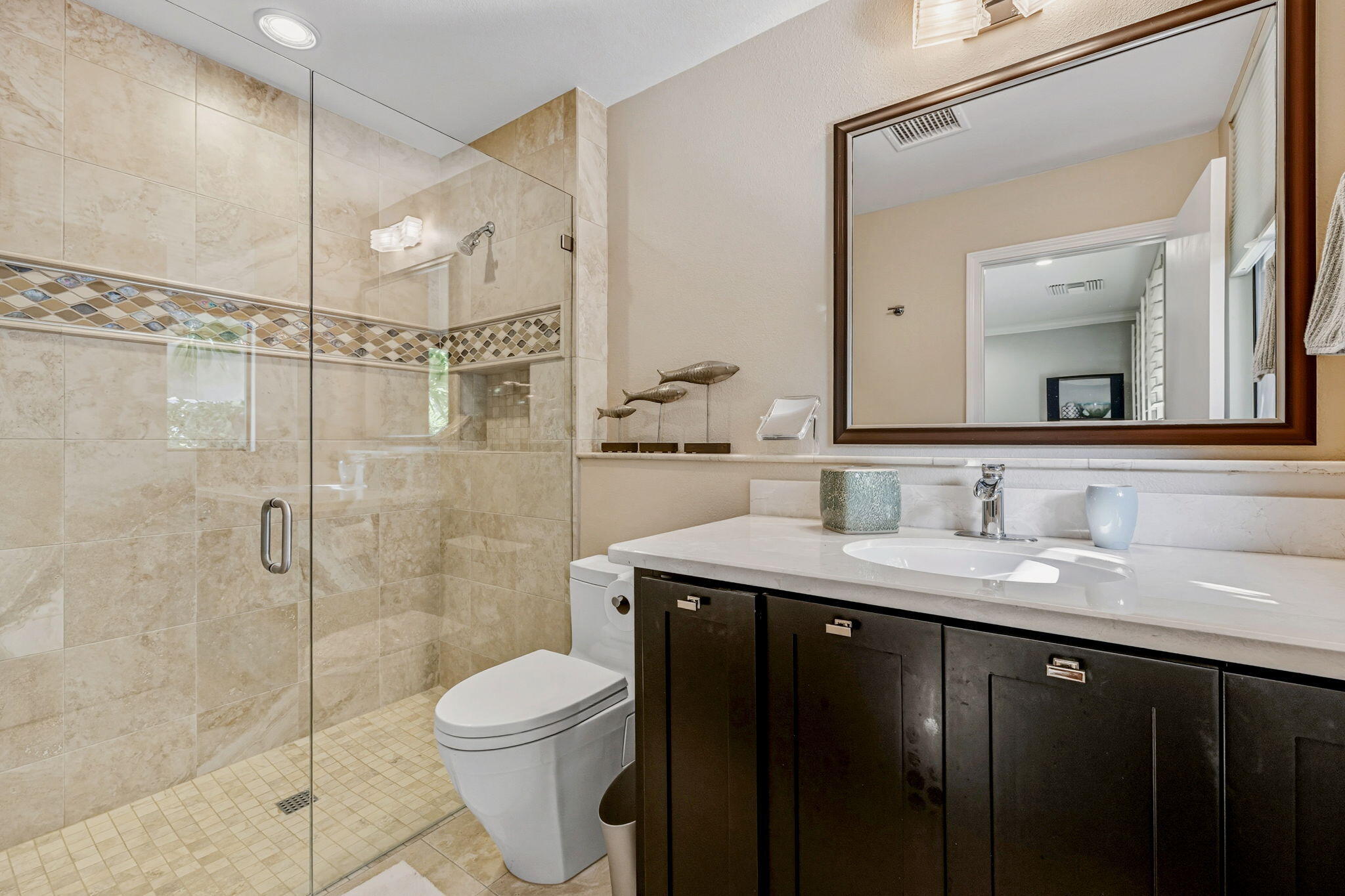 10 Whittier Court Rancho Mirage, CA 92270 - Photo 36 of 62 a bathroom with a granite countertop sink toilet a mirror a vanity and shower