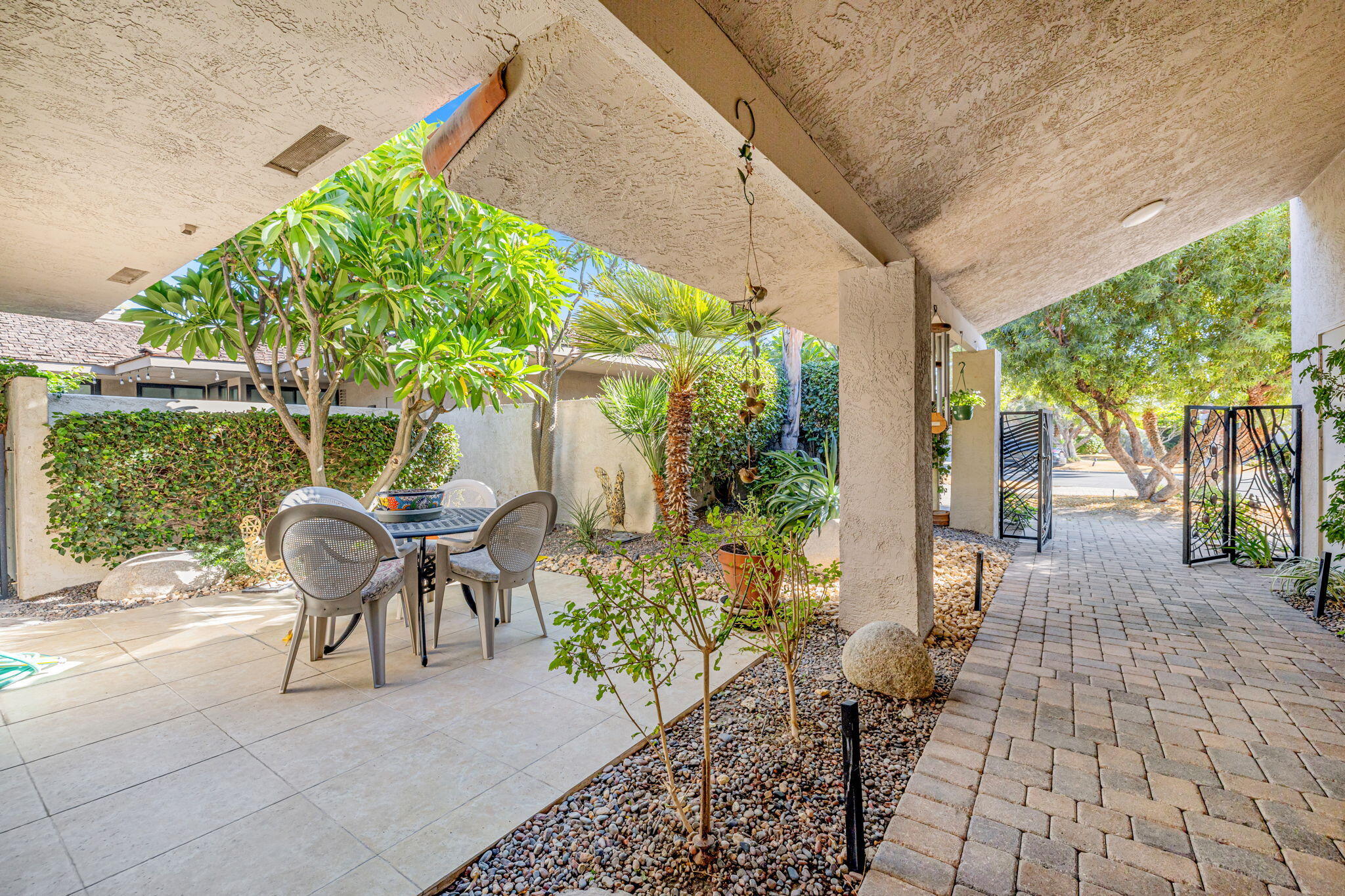 10 Whittier Court Rancho Mirage, CA 92270 - Photo 5 of 62 a view of a patio with table and chairs potted plants with wooden floor and fence
