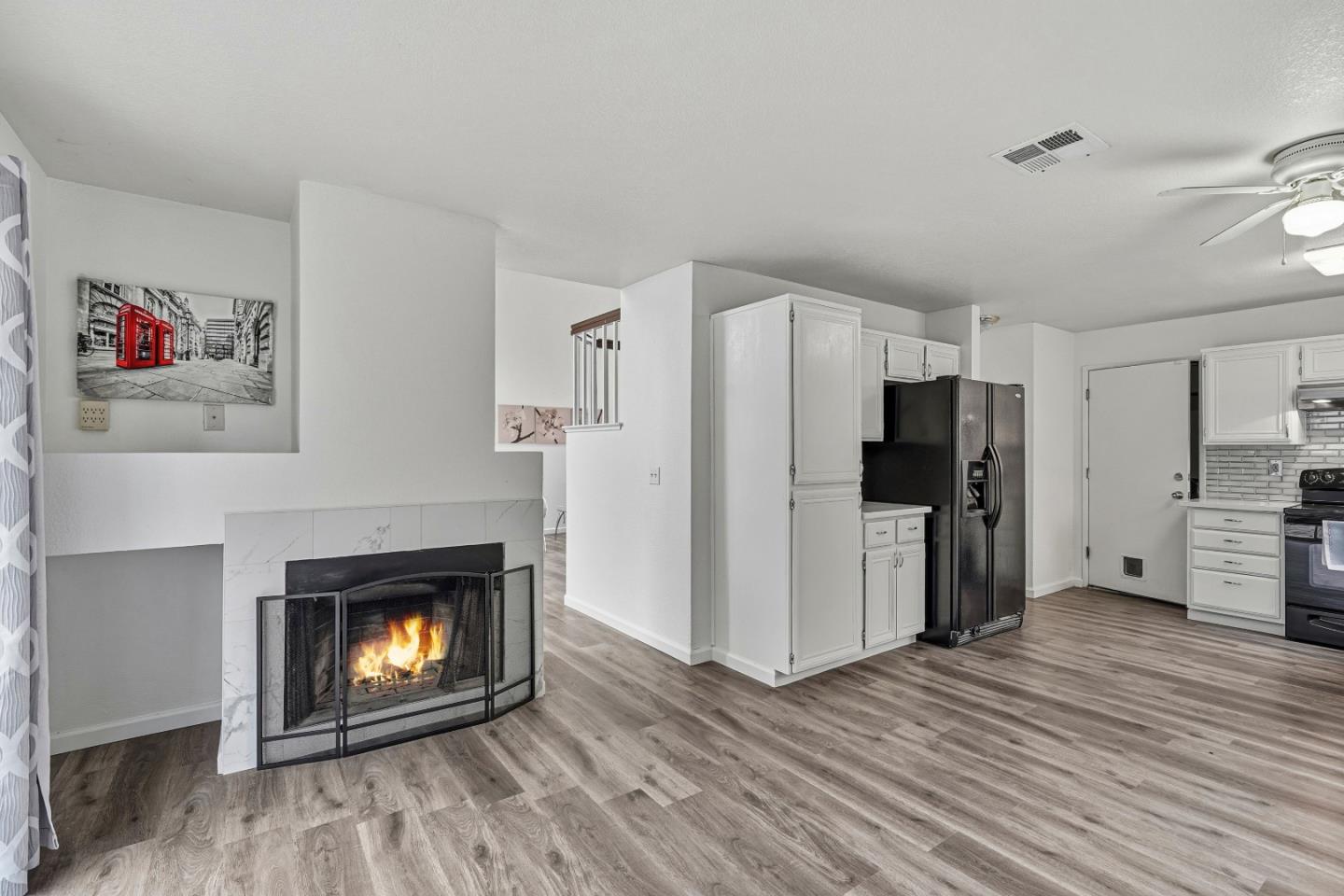 521 Leamon Street Tracy, CA 95376 - Photo 13 of 31 a living room with stainless steel appliances a fireplace a flat screen tv and a refrigerator