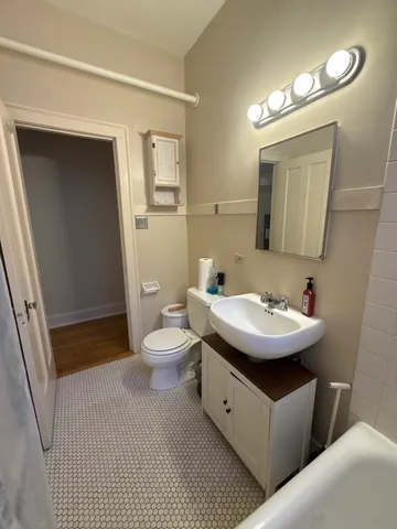 a bathroom with a sink a toilet and mirror