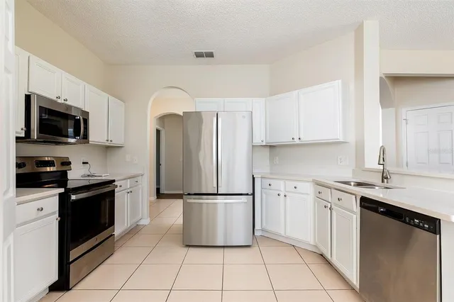 a kitchen with stainless steel appliances granite countertop a refrigerator sink and stove