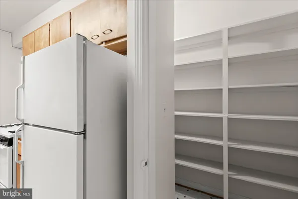 a white refrigerator freezer and a wooden floor